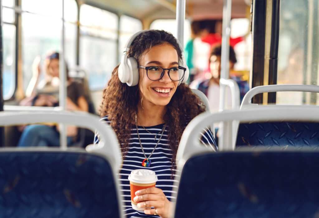 Woman wearing headphones riding the bus